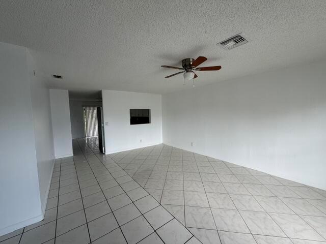An empty room with white walls, a ceiling fan, and light-colored diagonal floor tiles — 7355 Pinedale Drive, Boynton Beach FL 33436, BOYNTON BEACH, FL