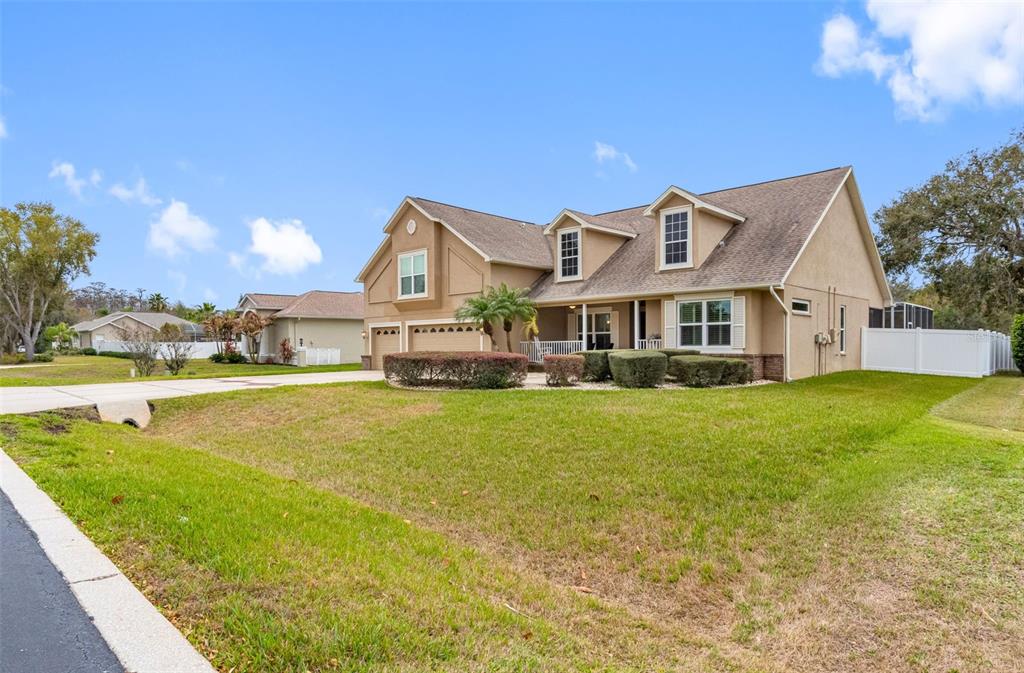A two-story tan house with a multi-car garage and a large front lawn — 6224 ROCKROSS AVENUE, NEW PORT RICHEY, FL