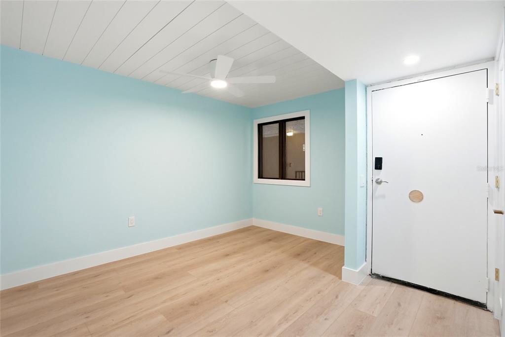 An empty room features light blue walls, wood-look flooring, and a white plank ceiling — 6035 SEA RANCH DRIVE UNIT 902, HUDSON, FL