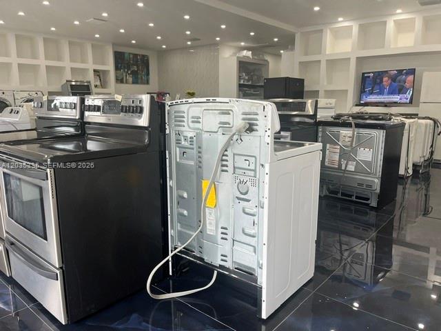 A showroom displays several stainless steel kitchen ranges on a dark, reflective floor — TAMARAC, FL