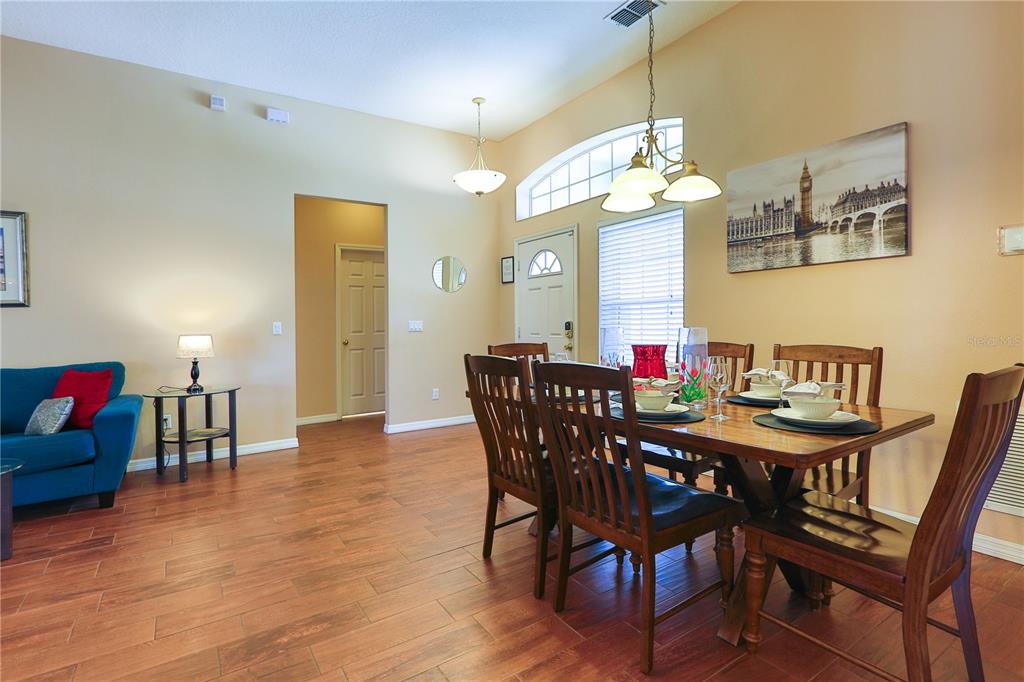 A dining area with a wooden table and chairs sits adjacent to a living room — 331 HENLEY CIRCLE, DAVENPORT, FL