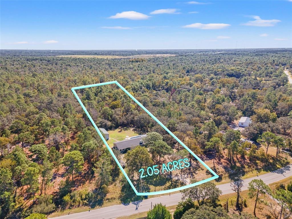 An aerial view shows a house and shed on a 2.05-acre wooded lot — 17504 THOMAS BOULEVARD, HUDSON, FL