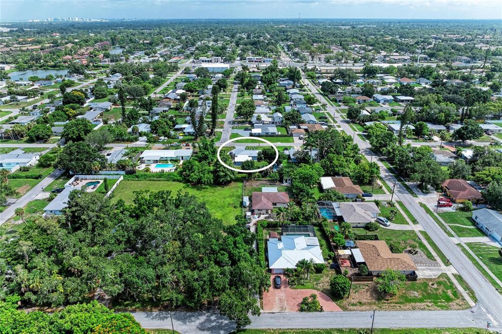 An aerial view shows a residential neighborhood with a single-story house circled in white — 3138 WILLIAMSBURG STREET, SARASOTA, FL