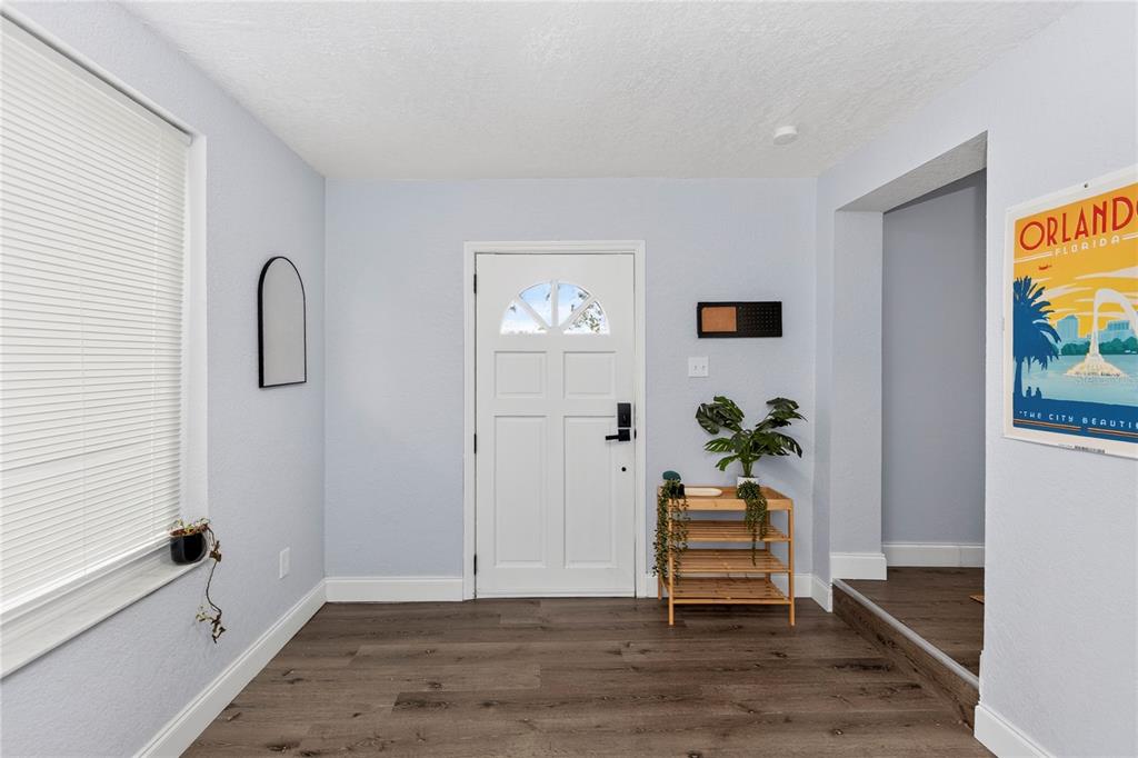 An entryway features light blue walls, dark wood-look flooring, a white front door, and shelving — 501 FITZGERALD DRIVE, MAITLAND, FL