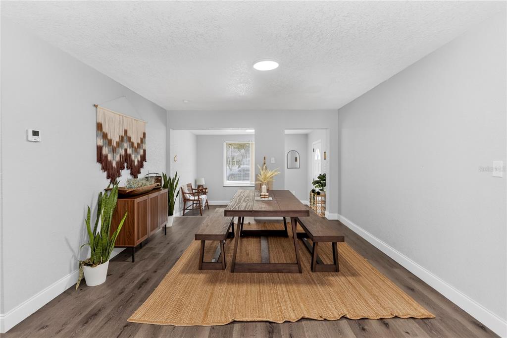 A dining room features a wooden table with benches on a rug over wood flooring — 501 FITZGERALD DRIVE, MAITLAND, FL