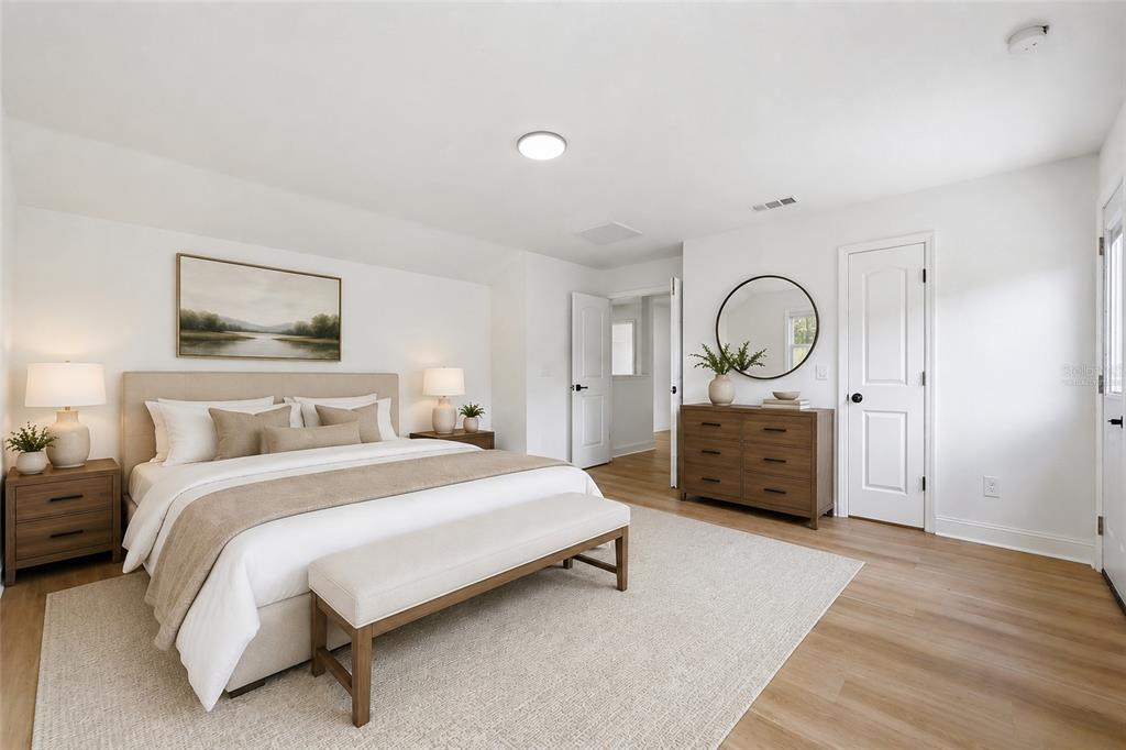 A bedroom features a bed with a beige headboard, a wooden dresser, and light flooring — 2124 CONTINENTAL STREET, ST CLOUD, FL
