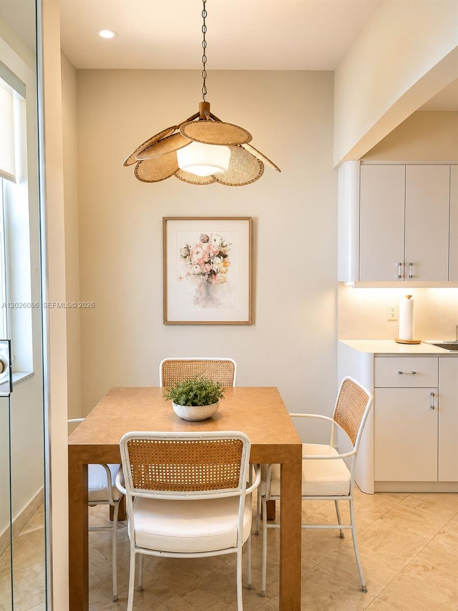 A dining area features a wooden table, cane-back chairs, and a decorative woven pendant light — 1865 S Ocean Drive # 21A, Hallandale Beach FL 33009, HALLANDALE BEACH, FL