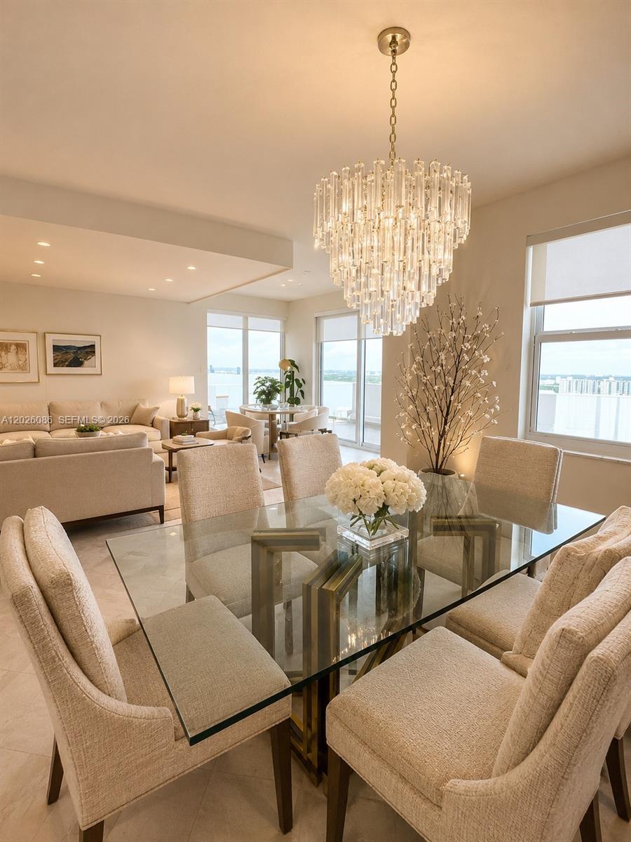A dining area with a glass table, upholstered chairs, and a crystal chandelier — 1865 S Ocean Drive # 21A, Hallandale Beach FL 33009, HALLANDALE BEACH, FL