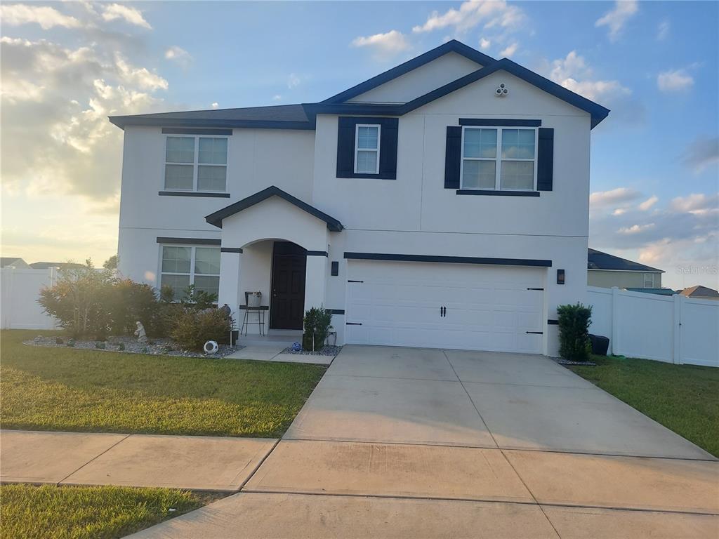 A two-story house with a white stucco exterior, dark trim, and a two-car garage — 4551 NE 27TH STREET, OCALA, FL