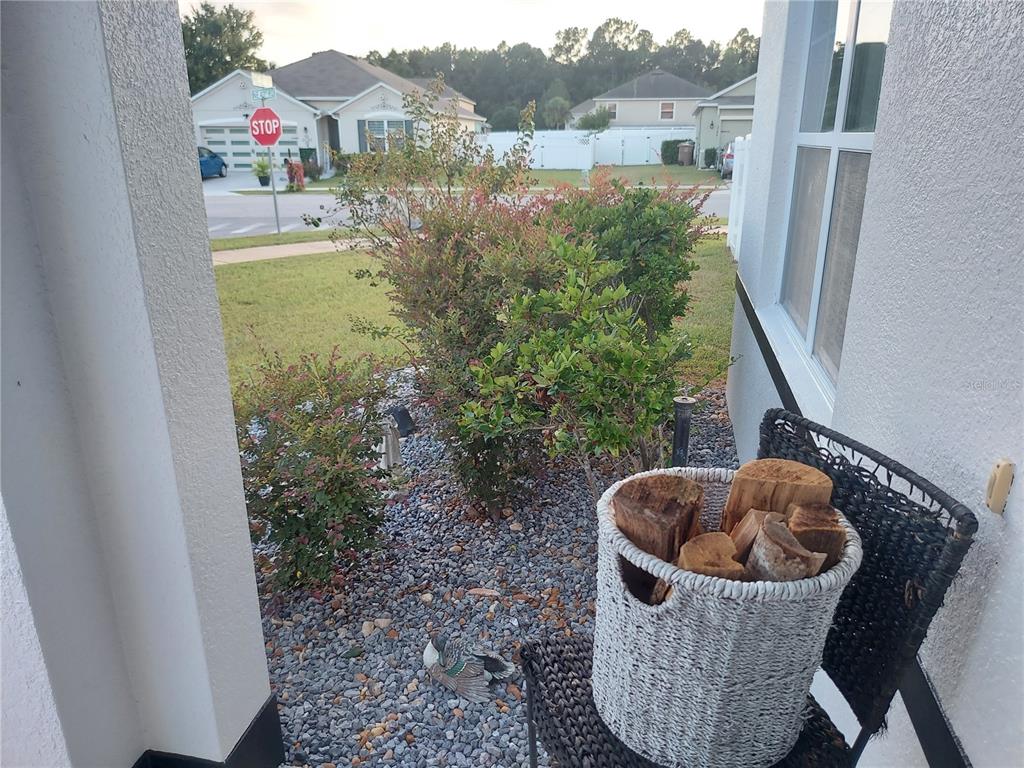 A view from a porch showing a gravel garden, a basket of firewood, and a street — 4551 NE 27TH STREET, OCALA, FL