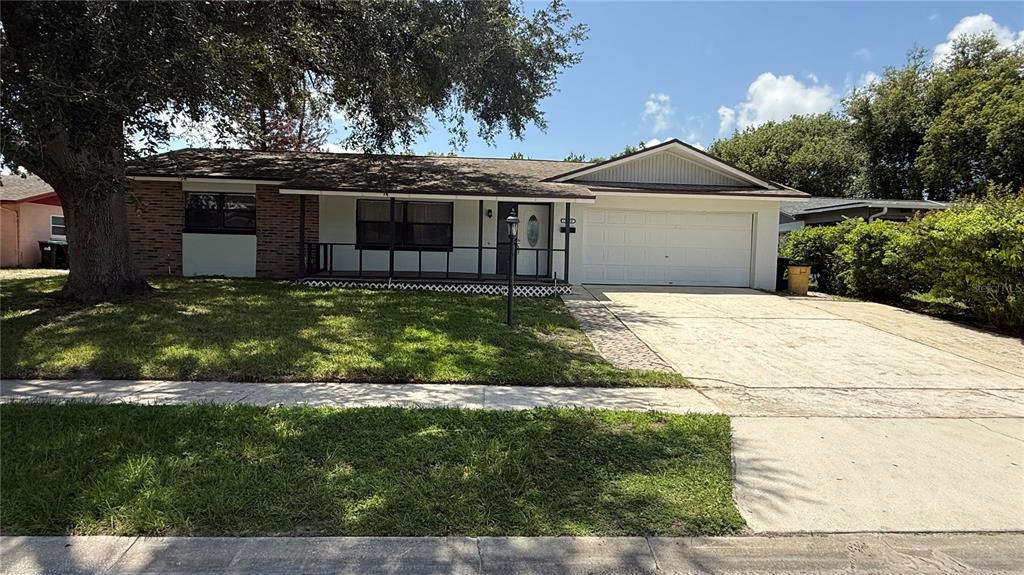 A single-story house with a brick facade, a front porch, and an attached two-car garage — 10630 EASTVIEW DRIVE, ORLANDO, FL