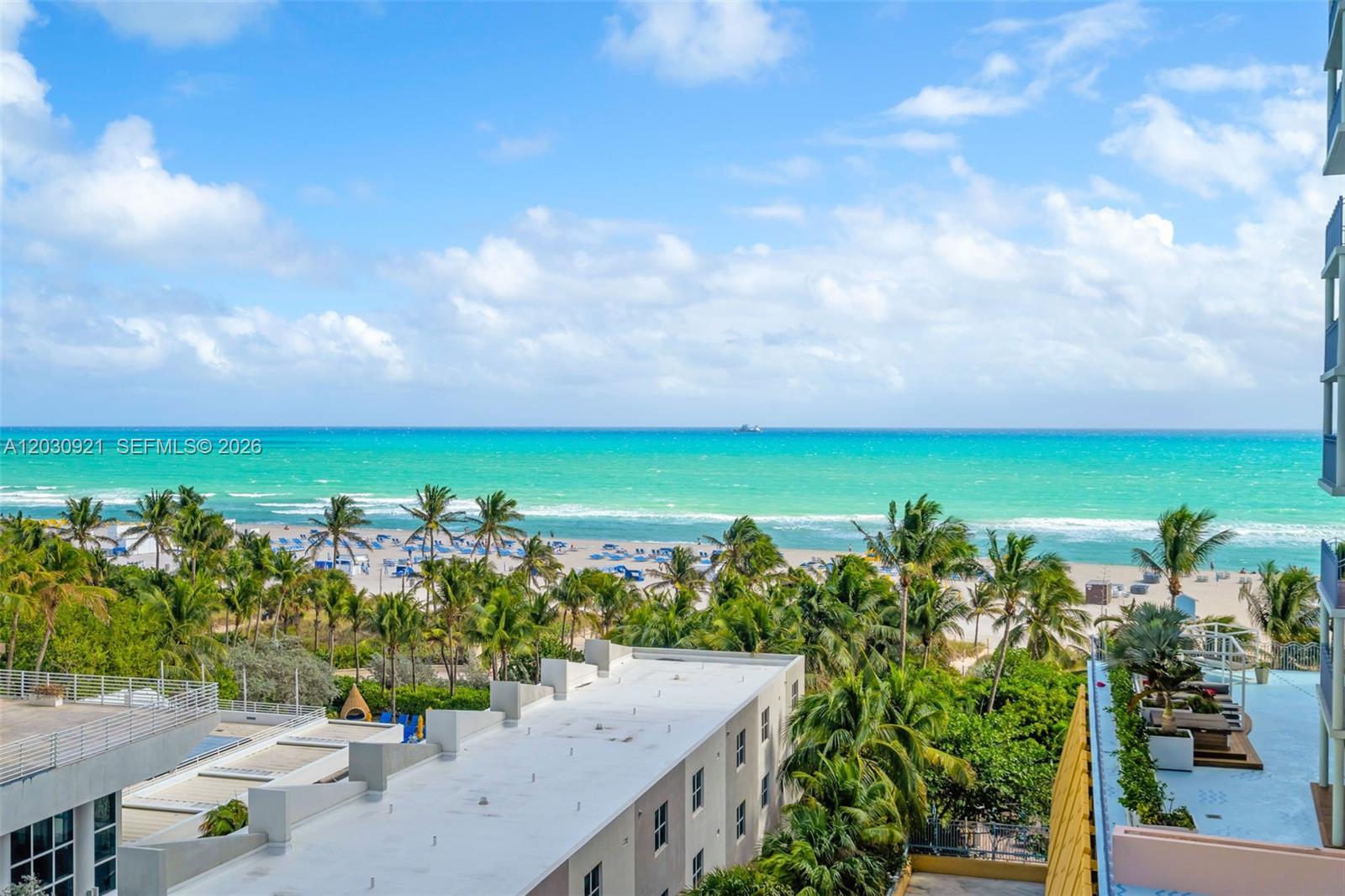 An elevated view of a beach with palm trees and the ocean under a blue sky — 1500 OCEAN DR # 707, Miami Beach FL 33139, MIAMI BEACH, FL