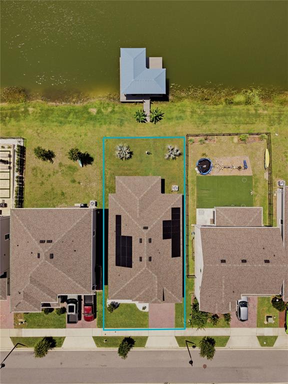 An aerial view shows a house with solar panels on its roof and a backyard — 5040 BESSIE COURT, ST CLOUD, FL