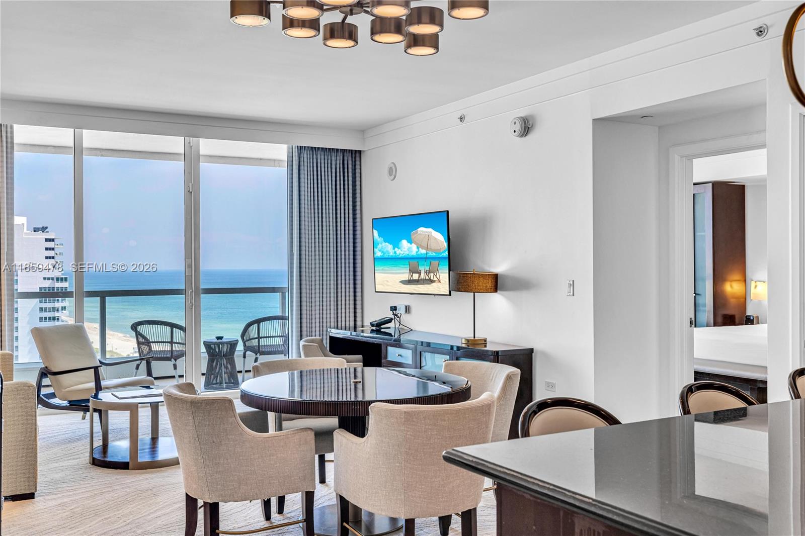 A dining area and living space overlook the ocean through large floor-to-ceiling windows — 4391 Collins Ave, Miami Beach FL 33140, MIAMI BEACH, FL