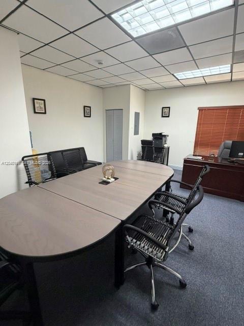 An office space features a large conference table, several chairs, and a desk near windows — 12150 SW 128th Ct Suite 218, Miami FL 33186, MIAMI, FL