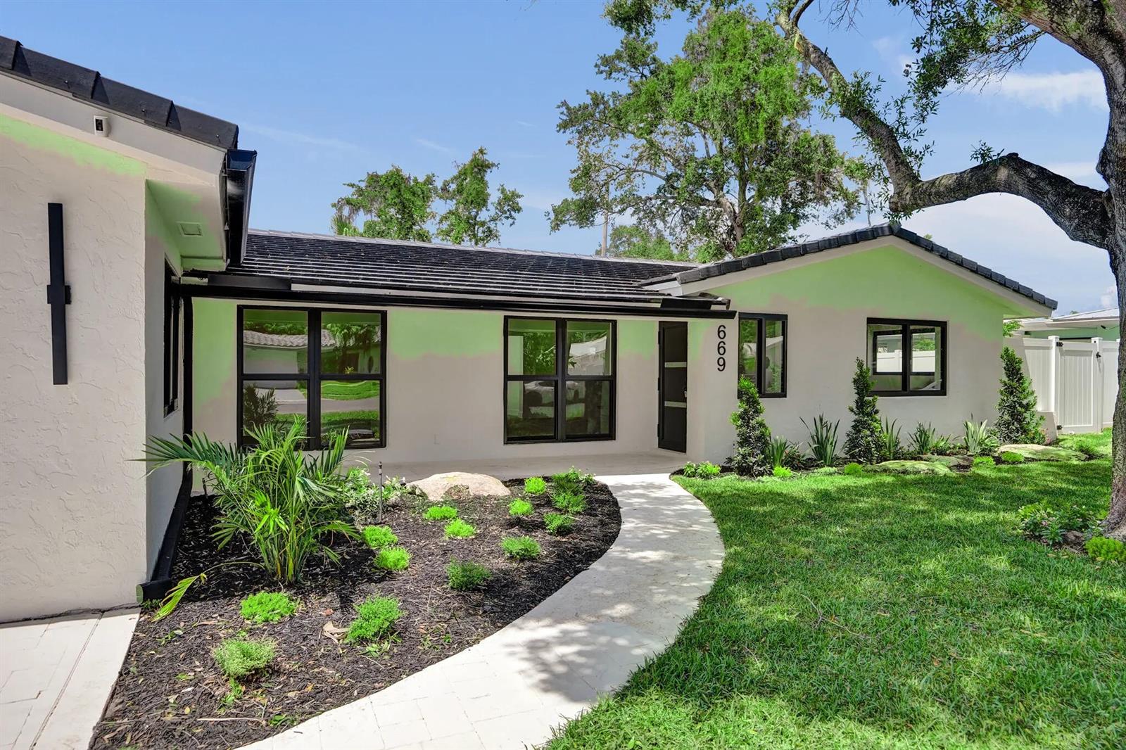 A single-story house with a white stucco exterior, black window frames, and a curved walkway — 669 SW 3rd Street, Boca Raton FL 33486, BOCA RATON, FL