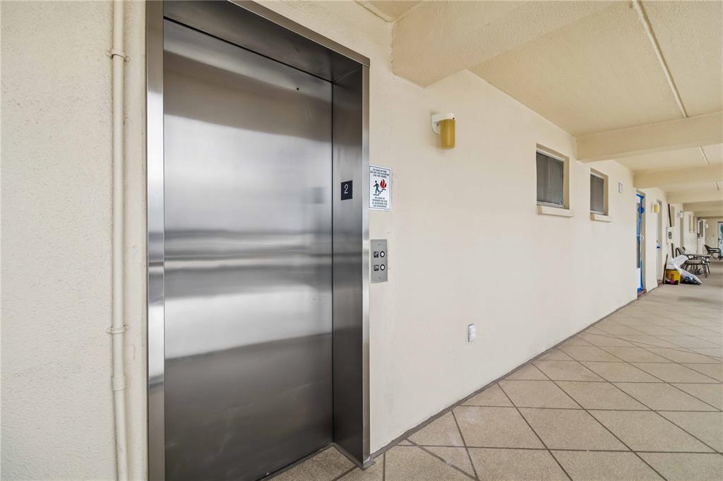 A stainless steel elevator door is located on a tiled outdoor walkway — 3804 GULF OF MEXICO DRIVE UNIT B204, LONGBOAT KEY, FL