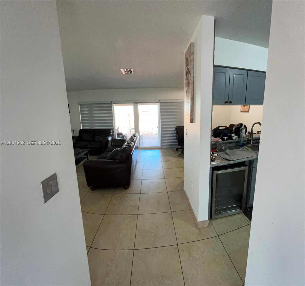 A view from a doorway looking into a living room and a small kitchen area — 9206 SW 147th Ct, Miami FL 33196, MIAMI, FL