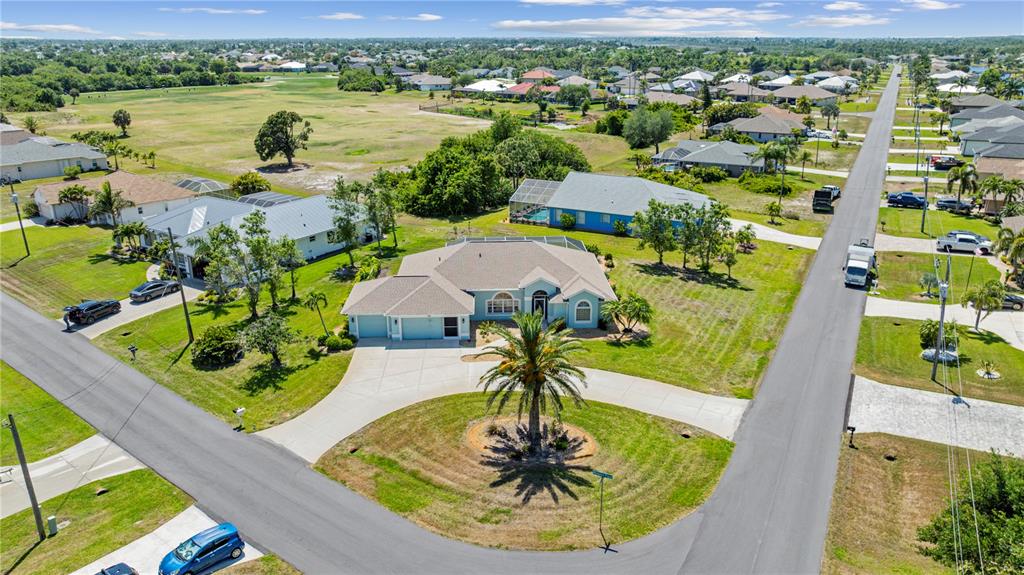 An aerial view shows a suburban house with a circular driveway and a palm tree — 54 MEDALIST PLACE, ROTONDA WEST, FL