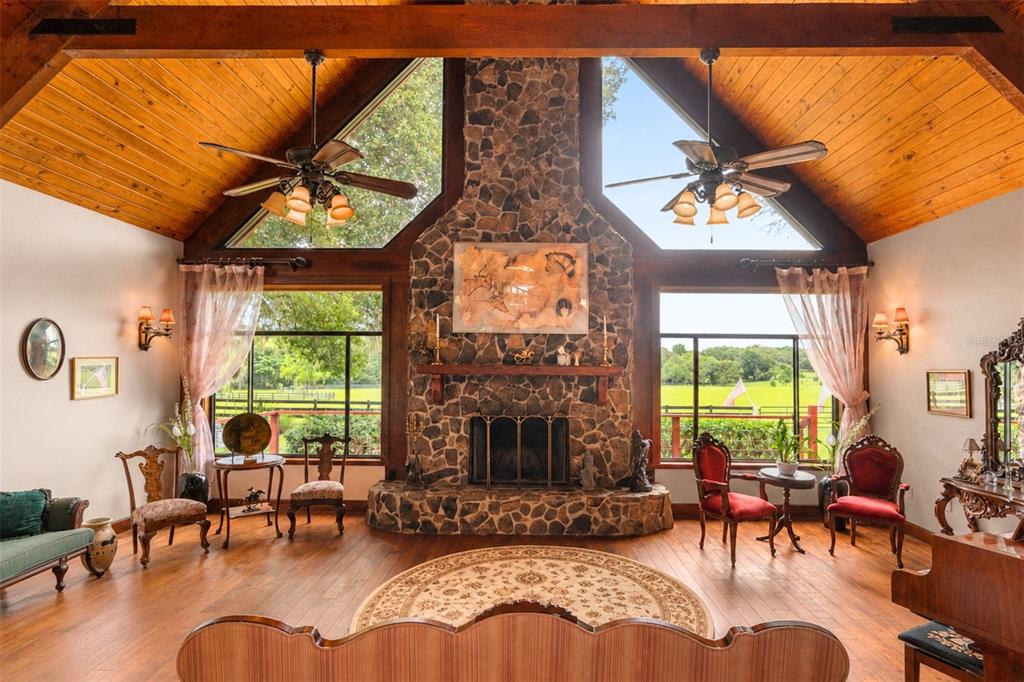 A spacious wooden deck features outdoor seating, a dining area, and a log cabin exterior — 35841 TIMBERTOP LANE, FRUITLAND PARK, FL