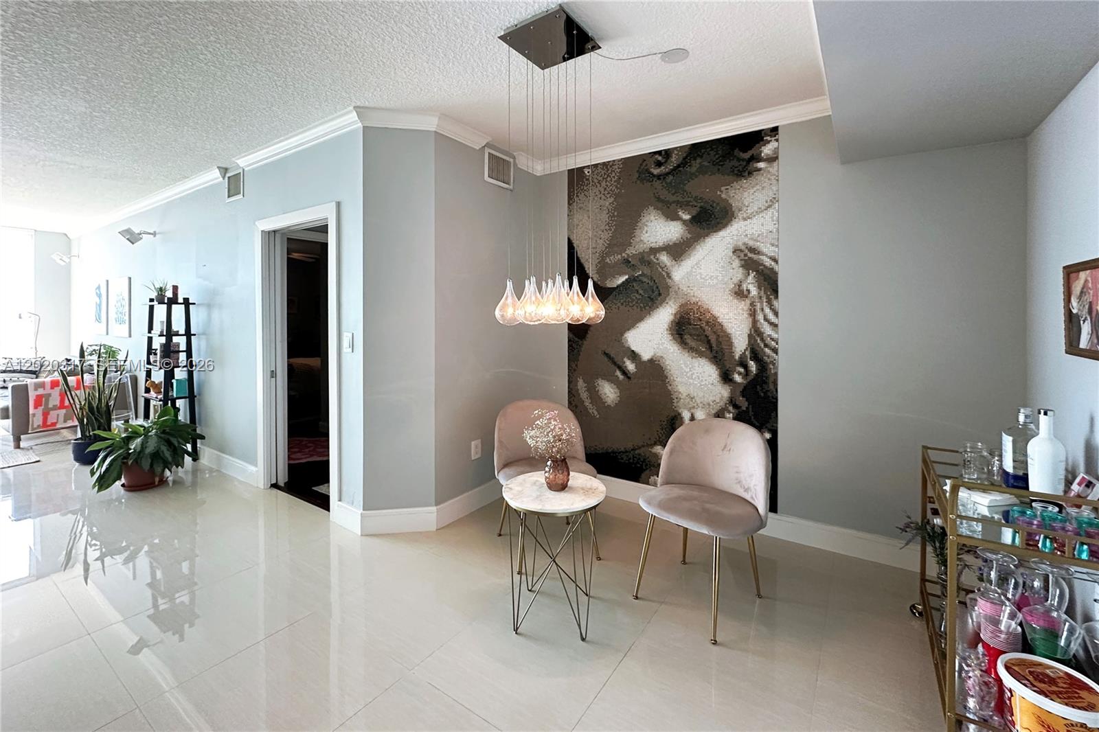 A dining area features a mosaic wall mural, pendant lighting, and two velvet chairs — 2000 N Bayshore Dr # 614, Miami FL 33137, MIAMI, FL