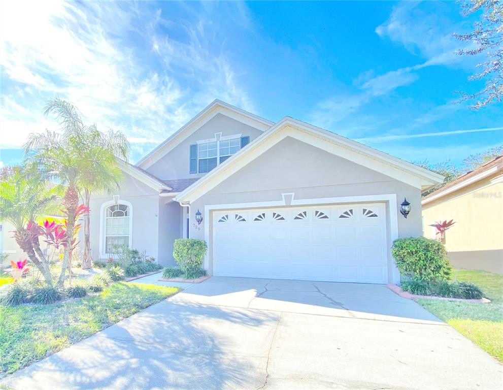 A single-story house with a two-car garage, a palm tree, and a concrete driveway — 729 TUTEN TRAIL, ORLANDO, FL