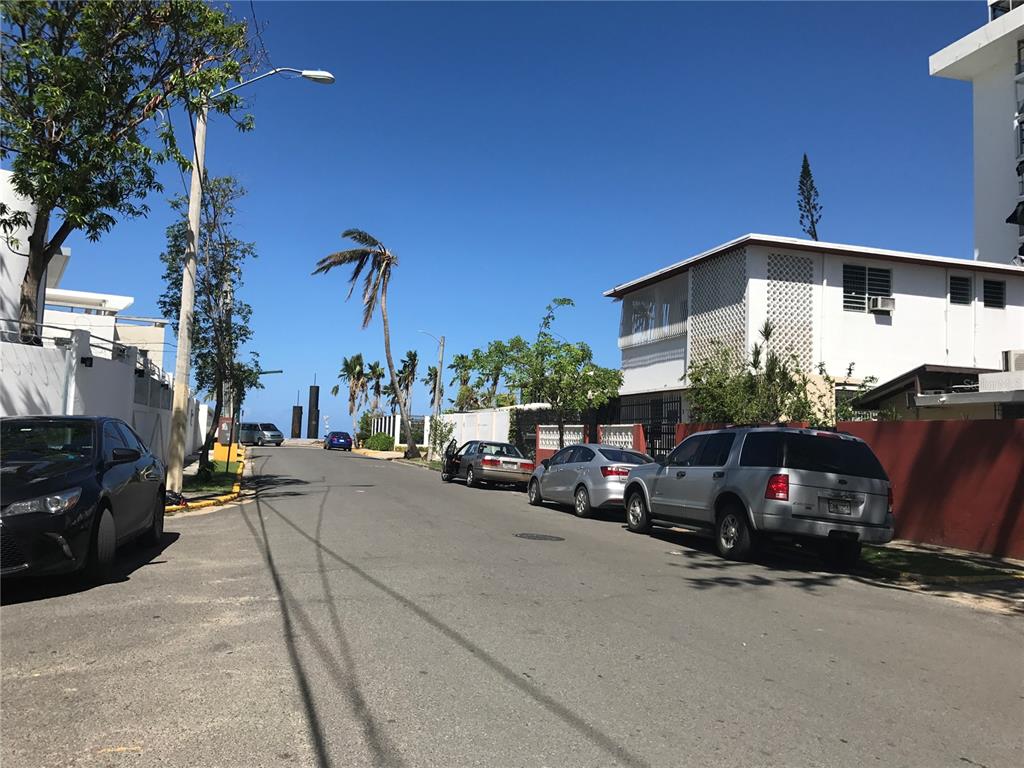 A street view showing parked cars along a road with houses and palm trees — 7 GUERRERO NOBLE UNIT 3, SAN JUAN, PR
