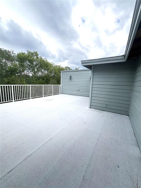 A large, flat-roofed outdoor deck with white railings and light gray horizontal siding — 1762 NW 34TH STREET UNIT 2, GAINESVILLE, FL