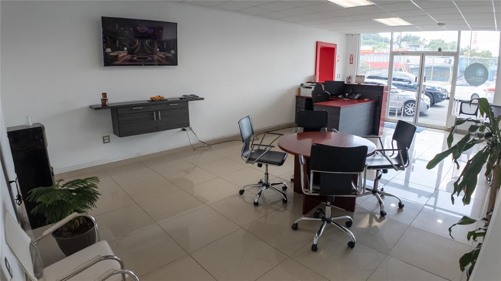 An office space features a round meeting table, chairs, a wall-mounted television, and tile flooring — San Agustin AVE 65TH INFANTERIA, SAN JUAN, PR