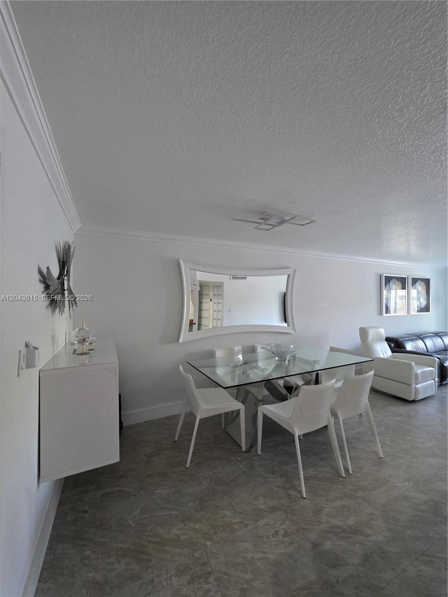 A dining area features a glass table, white chairs, a wall mirror, and tile flooring — 4670 W 13th Ln # 206, Hialeah FL 33012, HIALEAH, FL