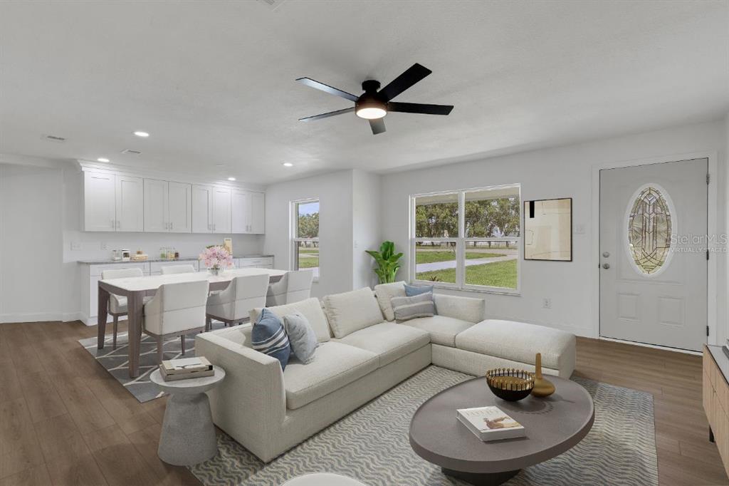 A virtually staged living room and dining area with white cabinets and wood-look flooring — 3400 SHEPHERD ROAD, MULBERRY, FL