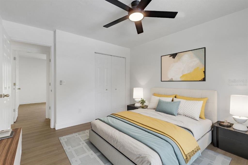 A bedroom features a bed with yellow and blue bedding, a ceiling fan, and white walls — 3400 SHEPHERD ROAD, MULBERRY, FL