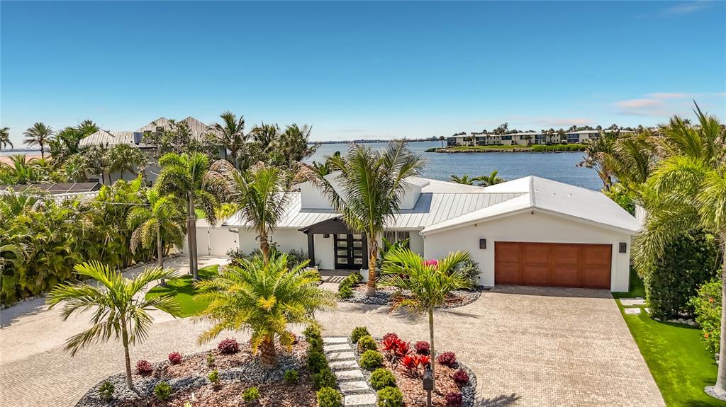 An aerial view of a white house with a metal roof and a paved driveway — 605 KEY ROYALE DRIVE, HOLMES BEACH, FL