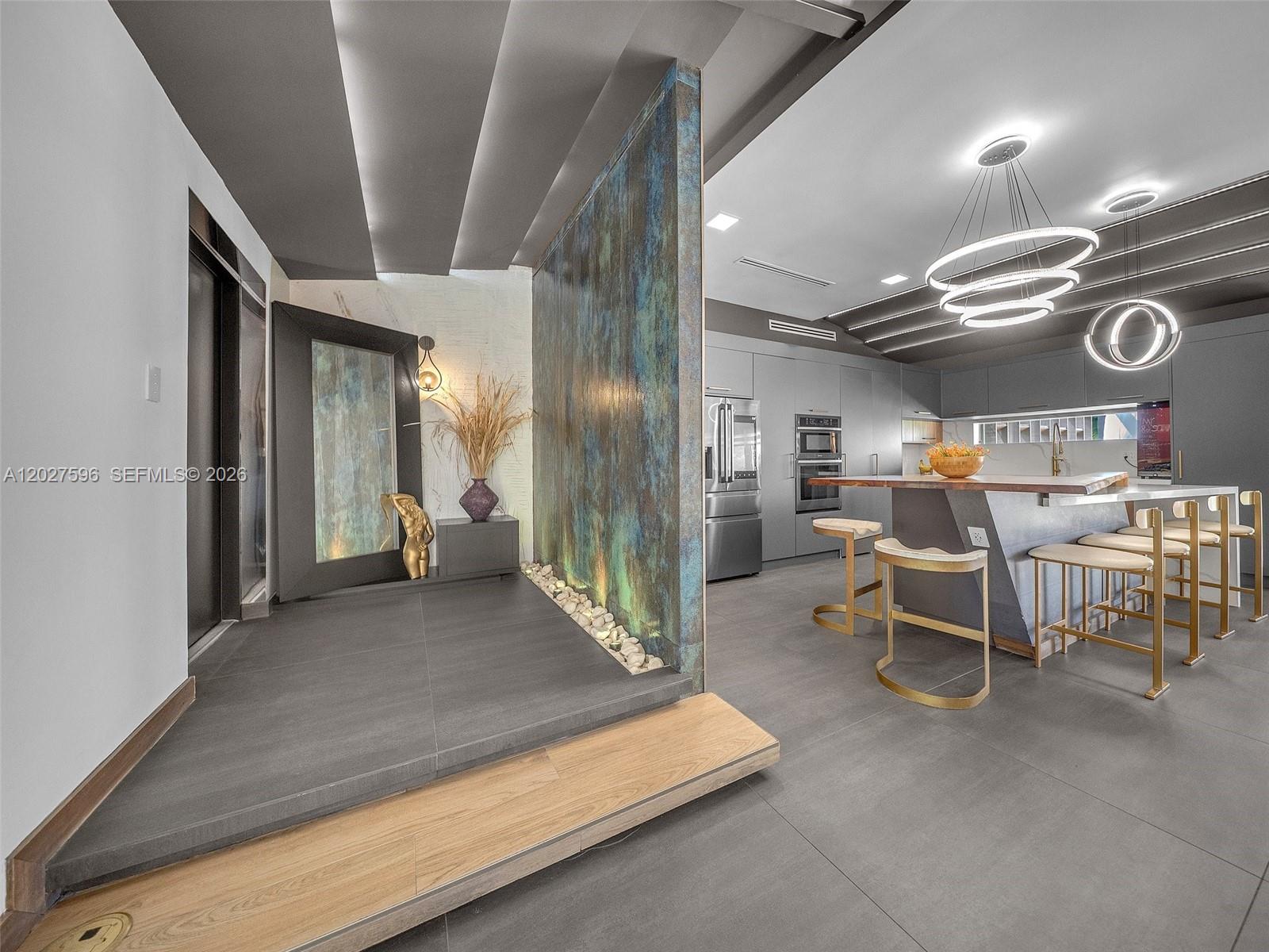 A modern kitchen features a raised entryway with a decorative patina wall and stone accents — 1141 Adams St, Hollywood FL 33019, HOLLYWOOD, FL