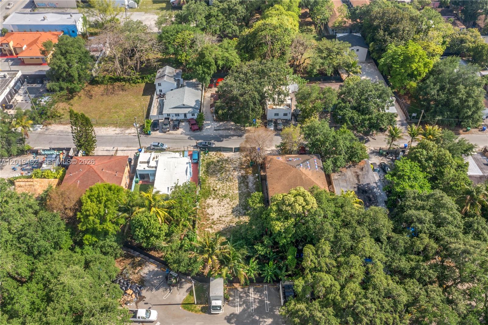 An aerial view shows a vacant lot situated between two residential buildings and dense trees — 161 NE 60th St, Miami FL 33137, MIAMI, FL