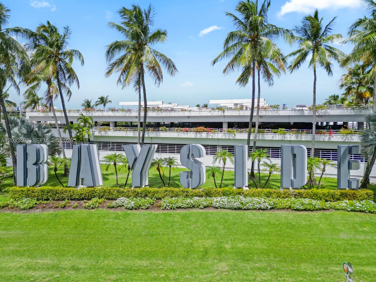 Large, three-dimensional letters spelling BAYSIDE stand on a grassy lawn before a parking structure — 398 NE 5th St # 3318, Miami FL 33132, MIAMI, FL