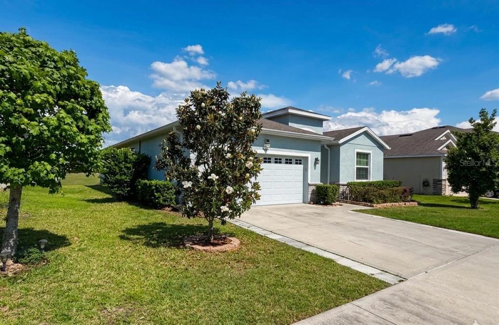 A light blue single-story house with a white garage door and a concrete driveway — 5703 SW 50TH AVENUE, OCALA, FL