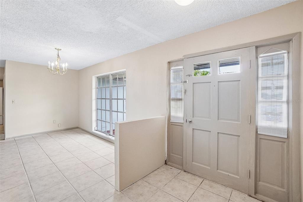 An entryway with light-colored tile flooring, a half wall, and a front door with sidelights — 1090 EDGEHILL AVE, SPRING HILL, FL