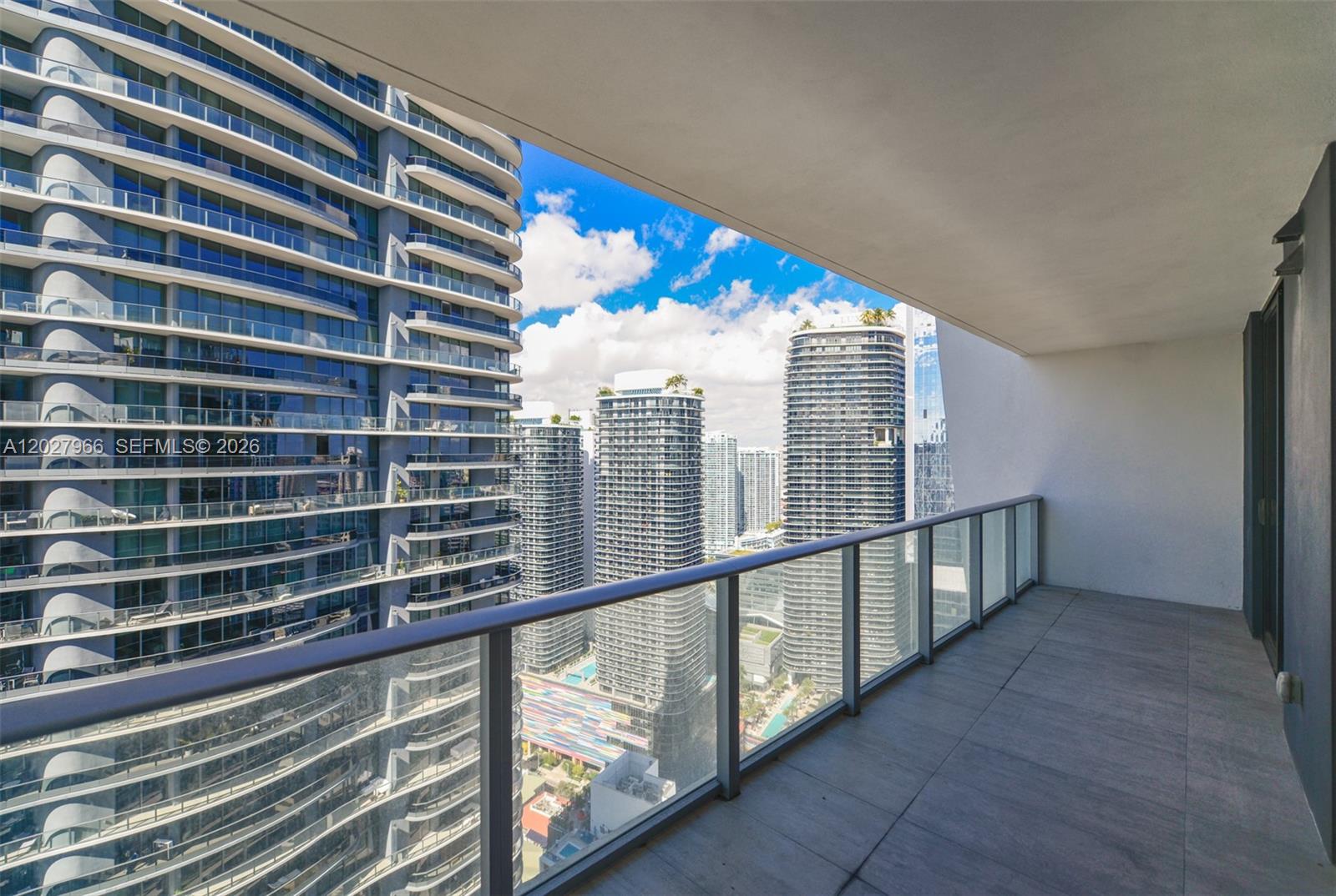 A balcony with a glass railing overlooks a dense urban skyline of high-rise buildings — 1010 Brickell Ave # 4607, Miami FL 33131, MIAMI, FL