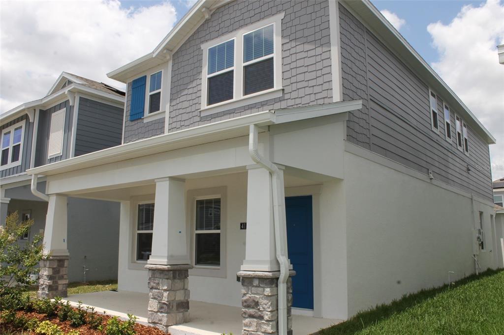 A two-story house with gray shingle siding, a front porch, and a blue front door — 4115 CONJUNCTION WAY, APOPKA, FL