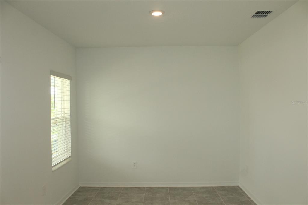 A small, empty room with white walls, tile flooring, and a single window with blinds — 4115 CONJUNCTION WAY, APOPKA, FL