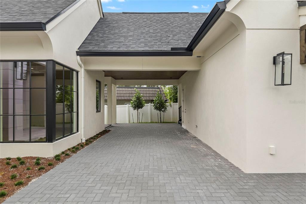 A paved driveway leads to a covered carport area between two sections of a house — 3222 HOLLIDAY AVE, APOPKA, FL