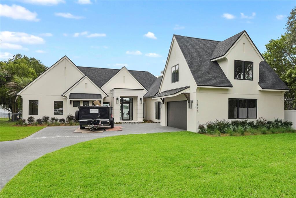 A modern two-story house with white stucco walls, a dark shingled roof, and a driveway — 3222 HOLLIDAY AVE, APOPKA, FL