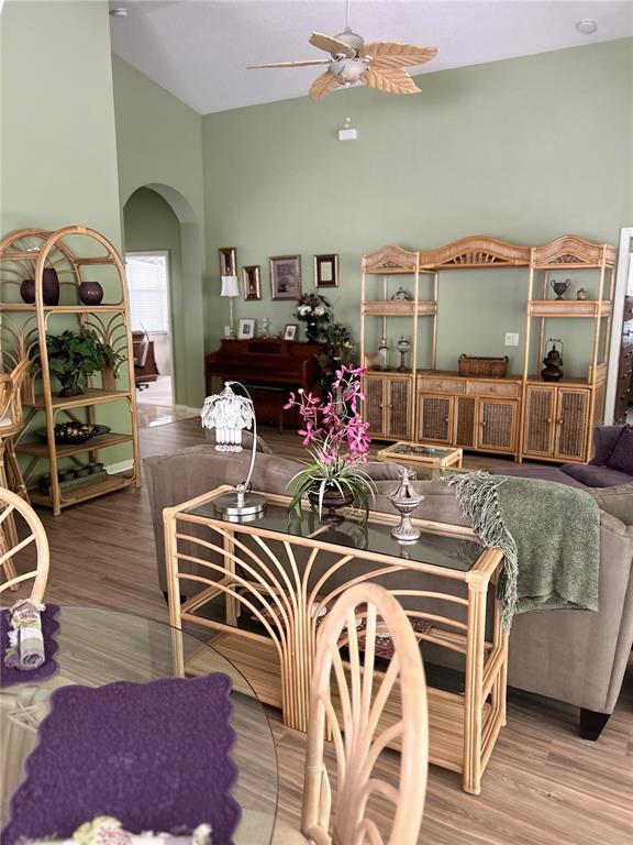 A living room features light green walls, rattan furniture, and a glass-topped console table — 2205 CALEDONIAN STREET, CLERMONT, FL