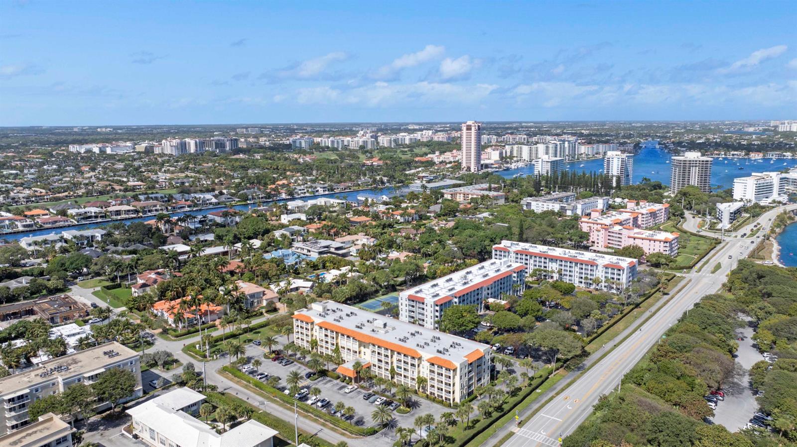 An aerial view shows residential apartment buildings, a road, and a waterway in Florida — 951 De Soto Road # 232, Boca Raton FL 33432, BOCA RATON, FL