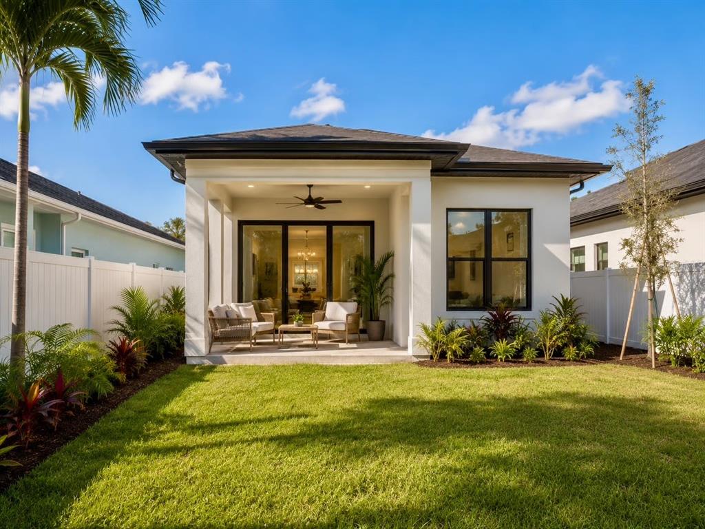 The exterior rear view of a modern house features a covered patio and grassy yard — 0 BLOSSOM AVENUE, TAMPA, FL