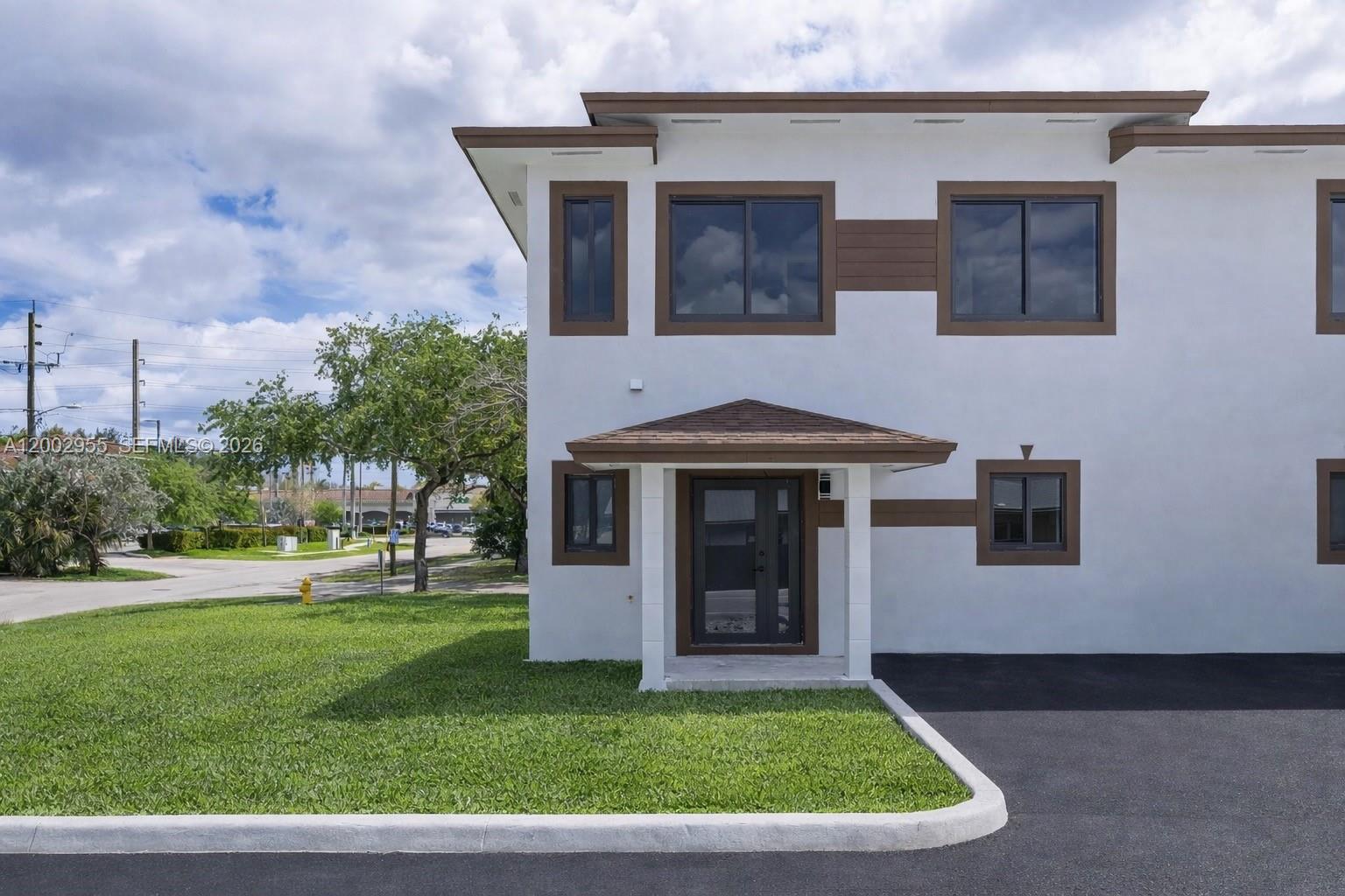 A two-story white building with brown trim features a front entrance and asphalt driveway — 4717 SW 32nd Ave, Dania Beach FL 33312, DANIA BEACH, FL