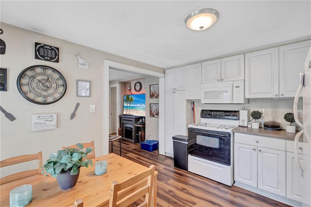 A kitchen with white cabinets and a dining area featuring a wooden table — 2521 4TH STREET S, ST PETERSBURG, FL