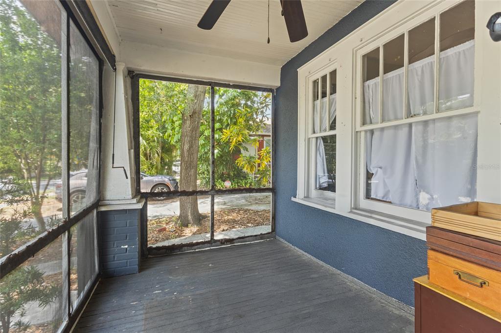A screened-in porch features a dark wood floor, blue walls, and a ceiling fan — 1413 N OSCEOLA AVENUE, CLEARWATER, FL