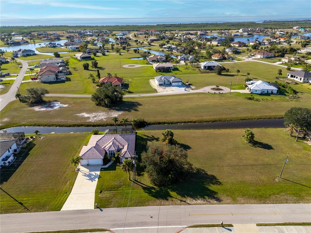 An aerial view shows a single-story house with a tiled roof and a large yard — 17277 CAPE HORN BOULEVARD, PUNTA GORDA, FL